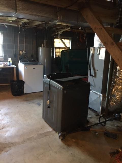 basement featuring washer and clothes dryer and water heater