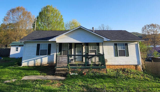 view of front of house with fence, a front yard, and covered porch