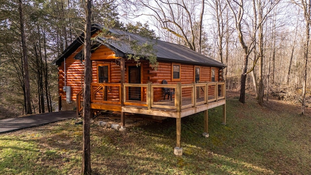 exterior space with metal roof, a deck, and log siding