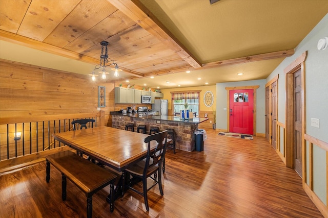 dining area featuring hardwood / wood-style floors, beam ceiling, wooden walls, and wooden ceiling