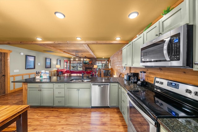 kitchen with sink, light hardwood / wood-style floors, kitchen peninsula, stainless steel appliances, and beam ceiling