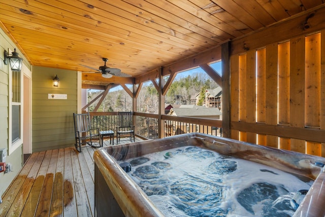 deck featuring ceiling fan and a hot tub