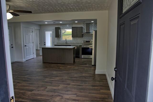 3646 Falcon Rd, Morristown, TN 37814 - kitchen featuring wall chimney exhaust hood, stainless steel range, a kitchen island, dark wood-style flooring, and recessed lighting