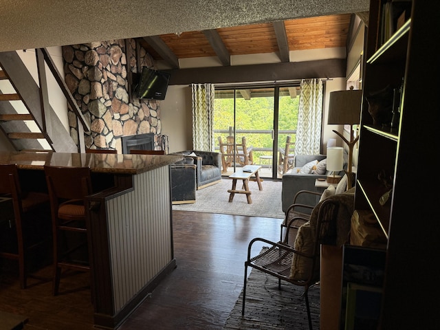 1081 Cove Rd Unit 734, Sevierville, TN 37876 - kitchen with open floor plan, dark wood-style flooring, a stone fireplace, a breakfast bar, and wood ceiling with exposed beams