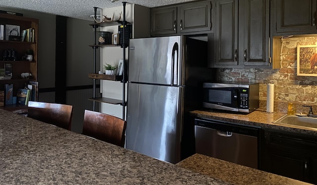 1081 Cove Rd Unit 734, Sevierville, TN 37876 - kitchen with appliances with stainless steel finishes, tasteful backsplash, a textured ceiling, and a sink