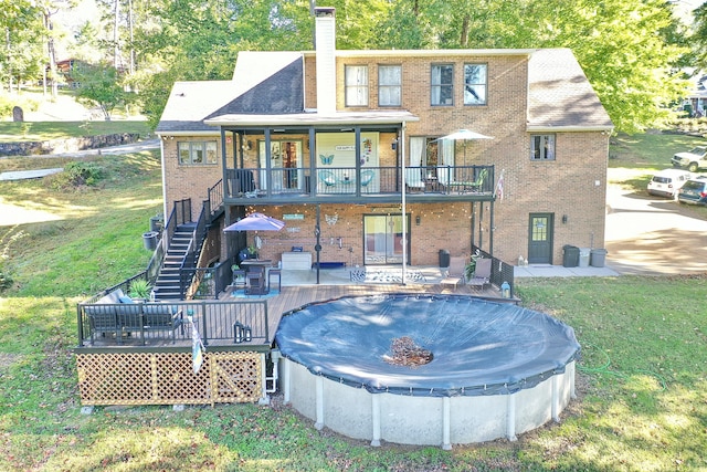 rear view of house featuring a yard, a patio, and a deck