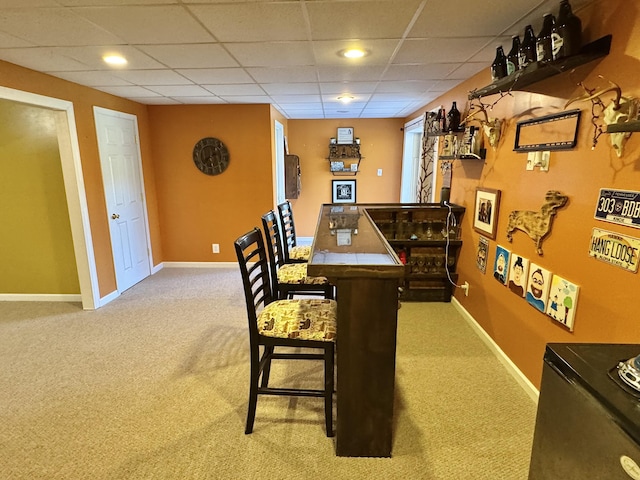 interior space featuring a paneled ceiling and carpet floors