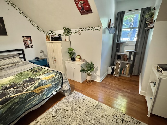 bedroom featuring hardwood / wood-style floors and lofted ceiling