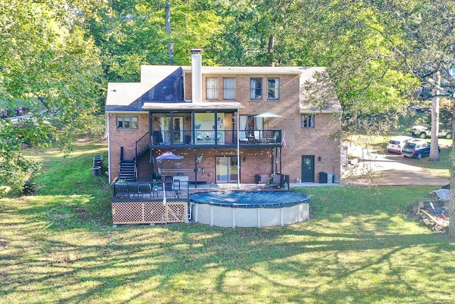 back of house with a lawn and a swimming pool side deck