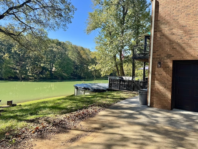 view of yard with a water view and a balcony