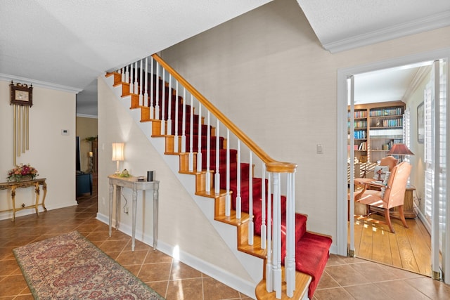 stairway with a textured ceiling, baseboards, tile patterned flooring, and crown molding