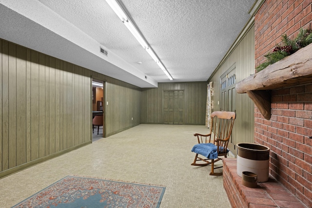 living area featuring carpet floors, visible vents, and a textured ceiling