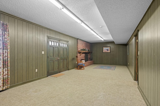 finished below grade area featuring a brick fireplace, carpet flooring, and a textured ceiling