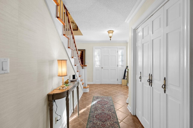 foyer entrance with light tile patterned floors, baseboards, stairway, a textured ceiling, and crown molding