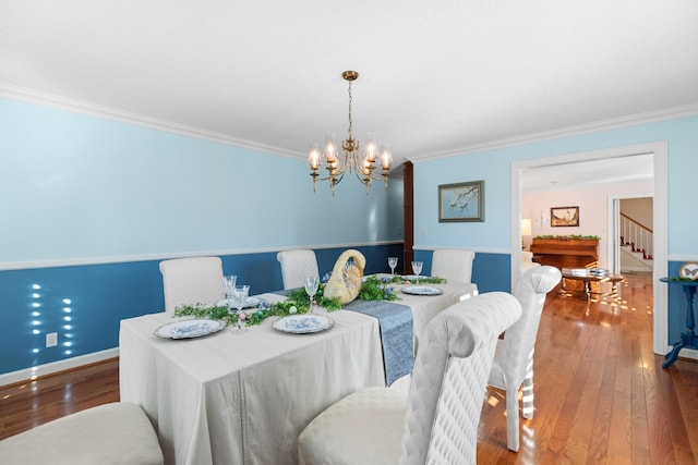 dining area with hardwood / wood-style flooring, a chandelier, and crown molding