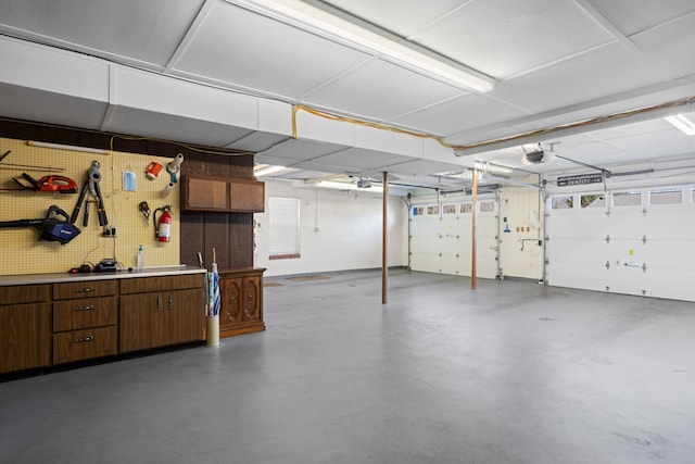 garage with a workshop area and a garage door opener