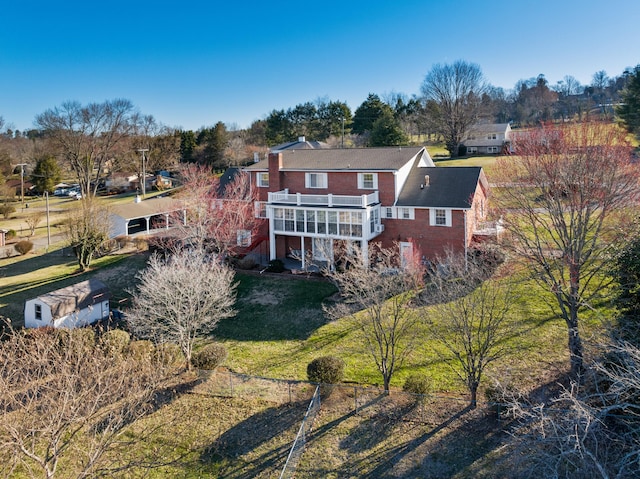 back of property with a deck, a yard, and brick siding