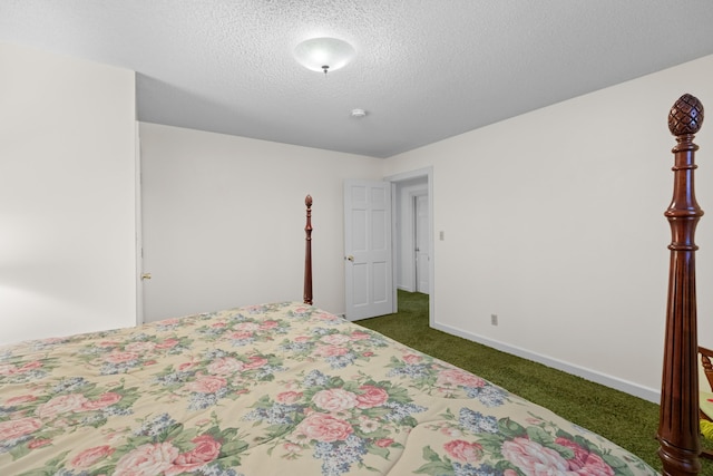 bedroom featuring baseboards, dark colored carpet, and a textured ceiling