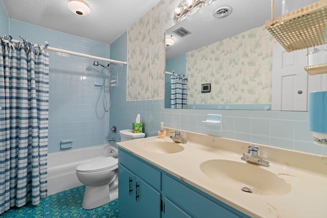 full bath with a textured ceiling, a wainscoted wall, a sink, and wallpapered walls