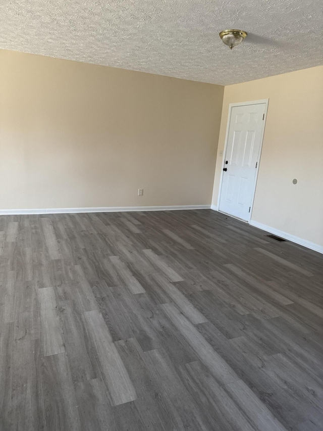 unfurnished room with dark hardwood / wood-style flooring and a textured ceiling