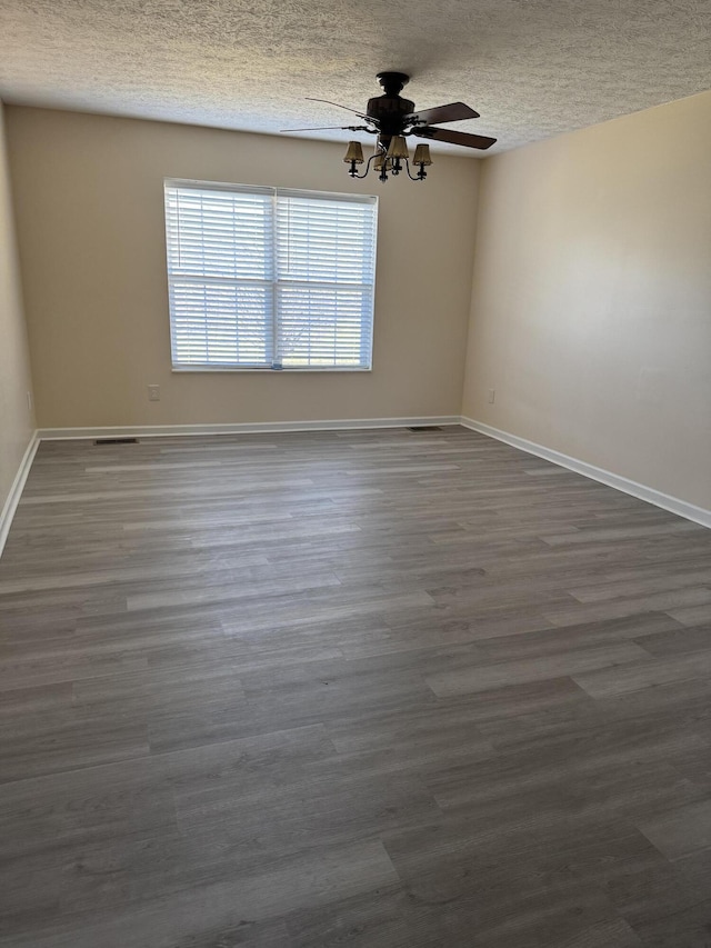 spare room featuring ceiling fan, dark hardwood / wood-style flooring, and a textured ceiling