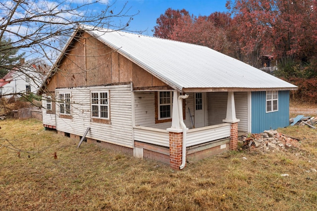 view of side of home with a lawn and a porch