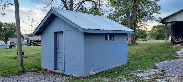 outdoor structure at dusk featuring a yard