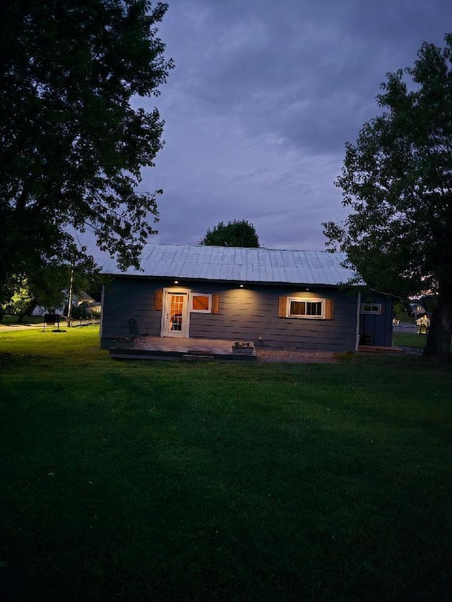 back of property with a lawn and metal roof