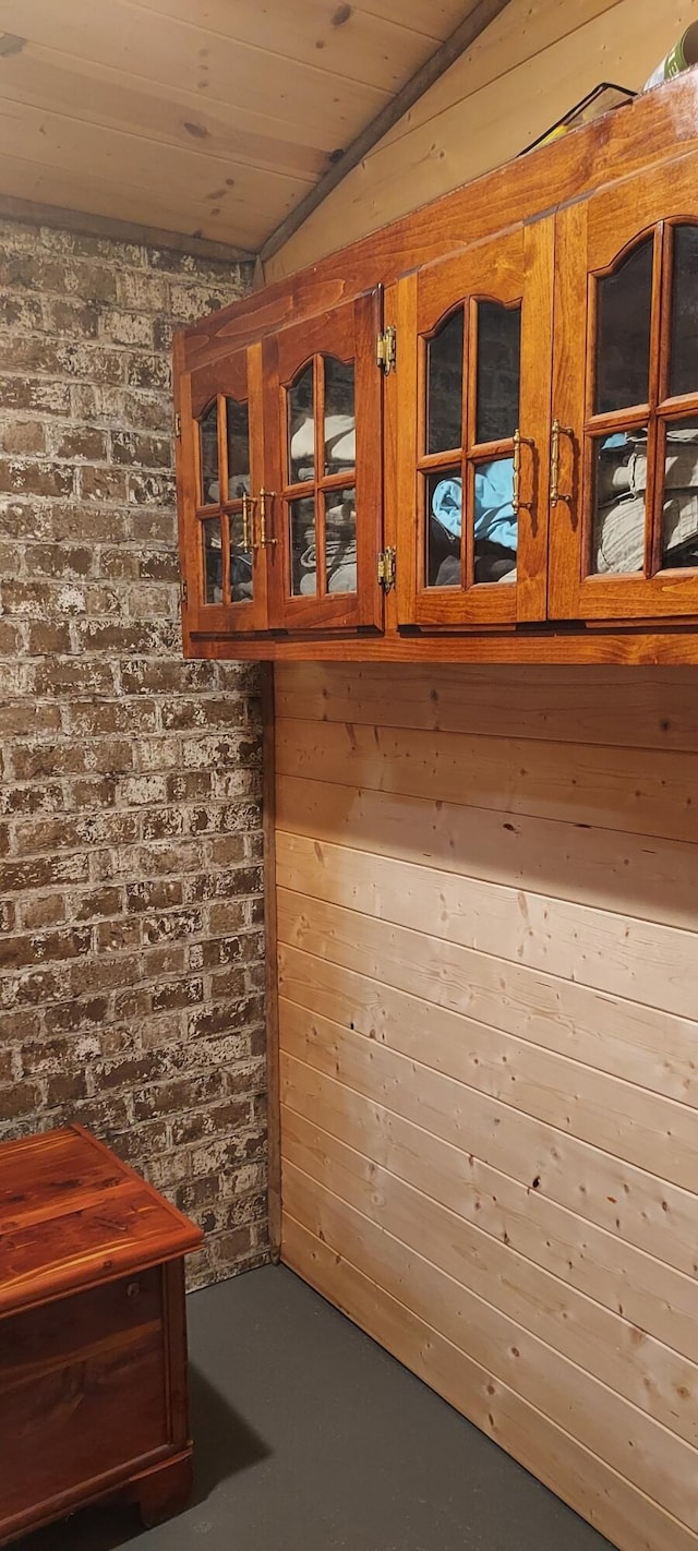 interior space with wooden ceiling, wood walls, and finished concrete flooring