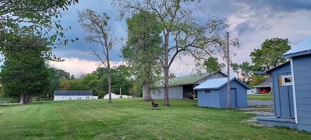 yard at dusk featuring a storage shed