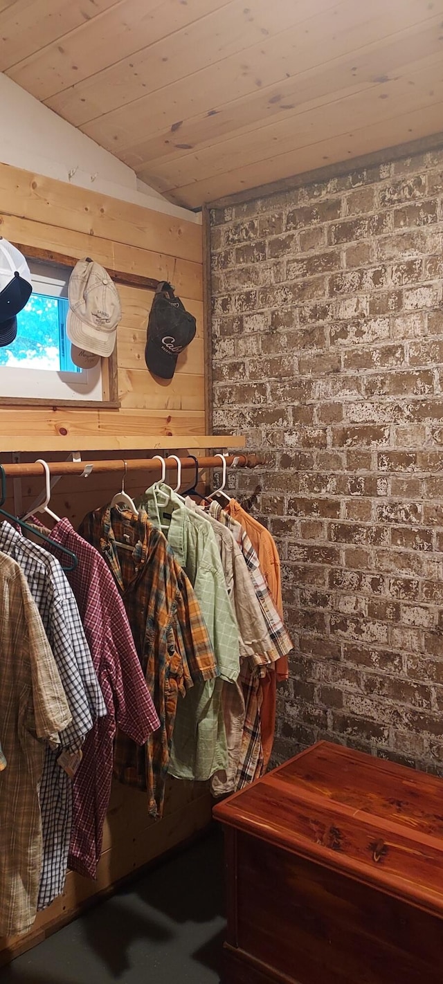 interior space featuring wood ceiling, brick wall, and wood walls