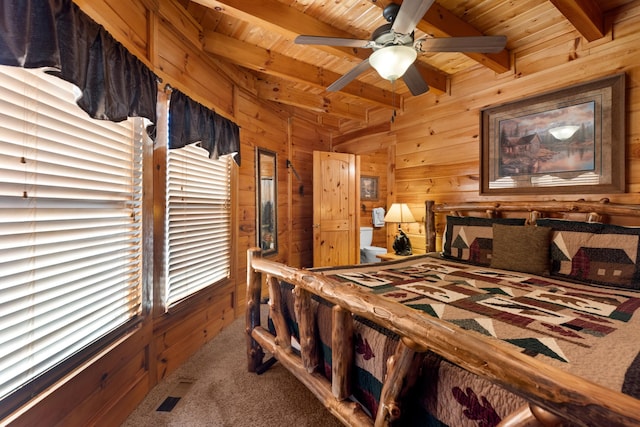 carpeted bedroom with wooden ceiling, wooden walls, visible vents, and beam ceiling