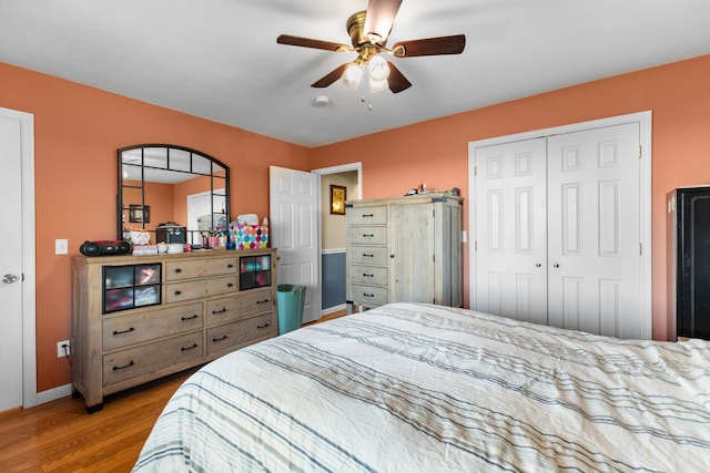 bedroom with wood finished floors, a closet, a ceiling fan, and baseboards