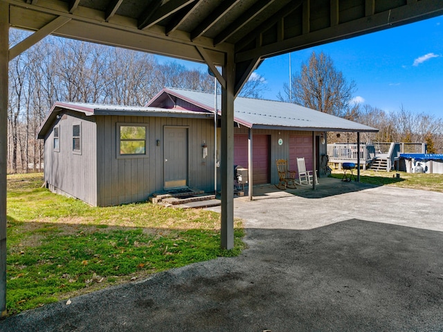 view of front of property featuring a garage, a front lawn, an outdoor structure, and metal roof