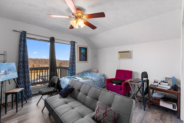 bedroom with lofted ceiling, wood finished floors, access to exterior, a wall mounted AC, and a textured ceiling