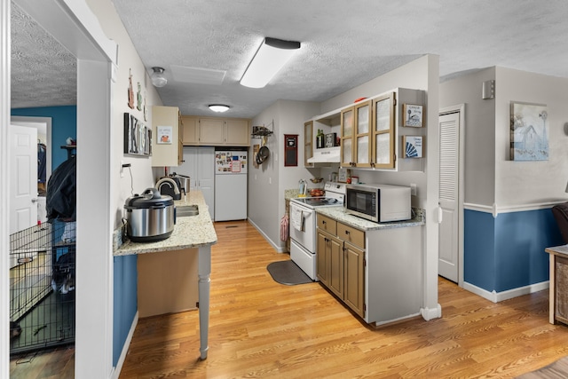 kitchen featuring under cabinet range hood, white range with electric stovetop, stainless steel microwave, fridge, and a textured ceiling