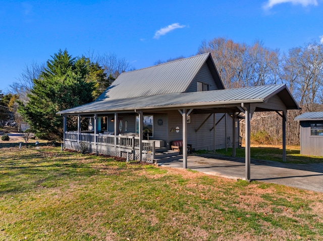 farmhouse-style home with covered porch, metal roof, and a front lawn