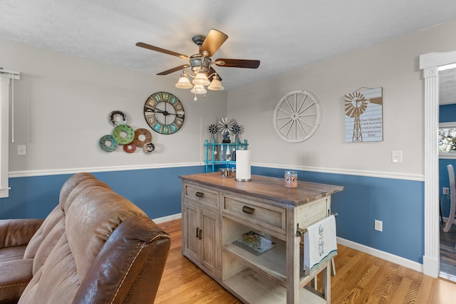 dining space with ceiling fan, baseboards, and light wood-type flooring