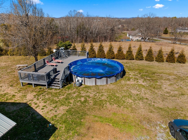 view of swimming pool with a yard, a deck, and a fenced in pool