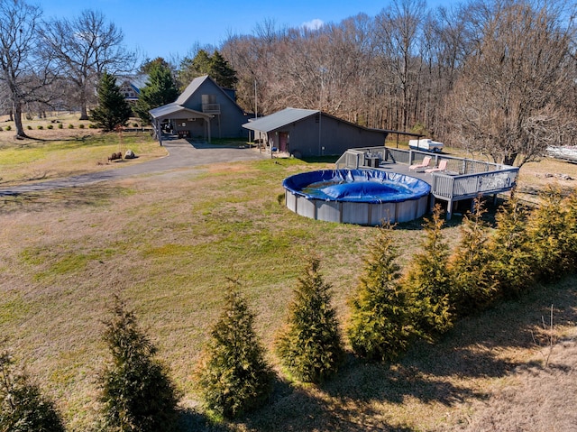 outdoor pool featuring a yard and a deck