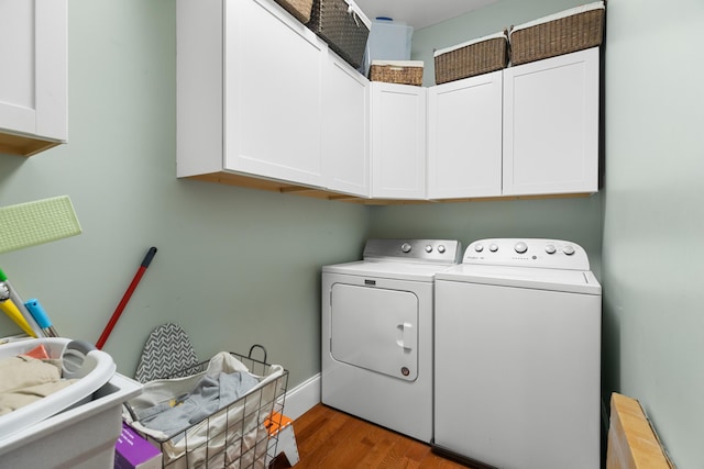laundry area featuring cabinet space, separate washer and dryer, and light wood-style floors
