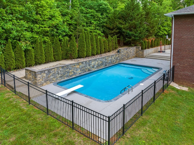 view of swimming pool featuring a diving board