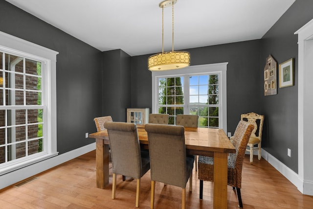 dining space with light wood-style floors and baseboards
