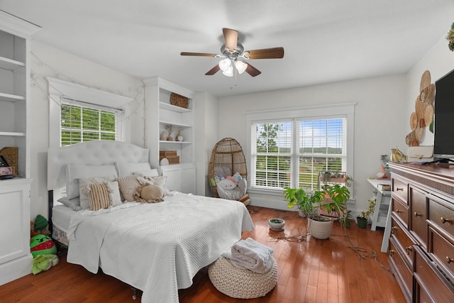 bedroom with multiple windows, wood finished floors, and a ceiling fan