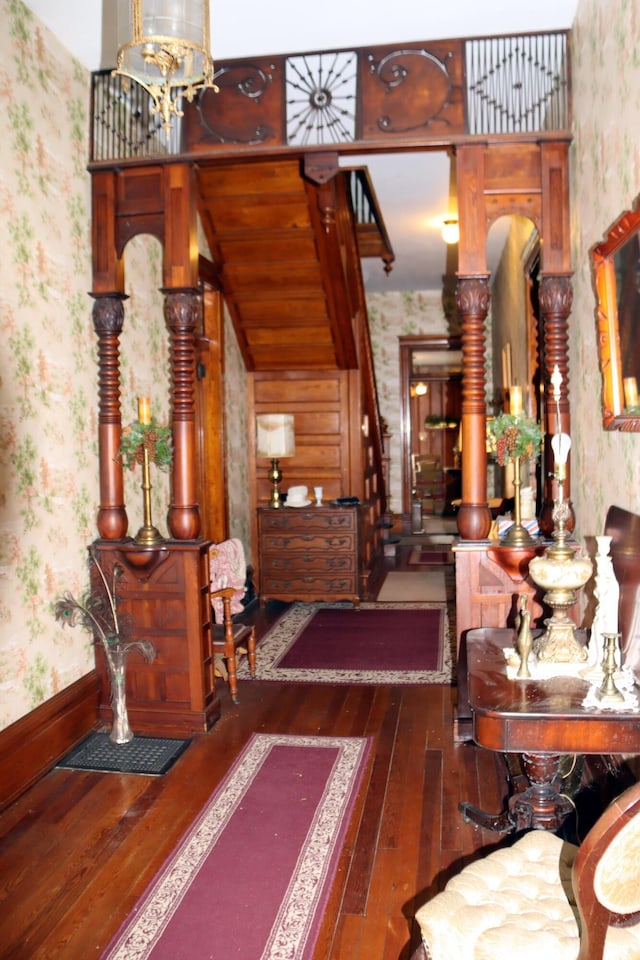 hallway with dark hardwood / wood-style floors and an inviting chandelier