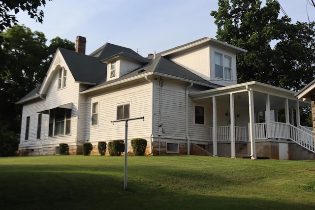 rear view of property featuring a porch and a yard