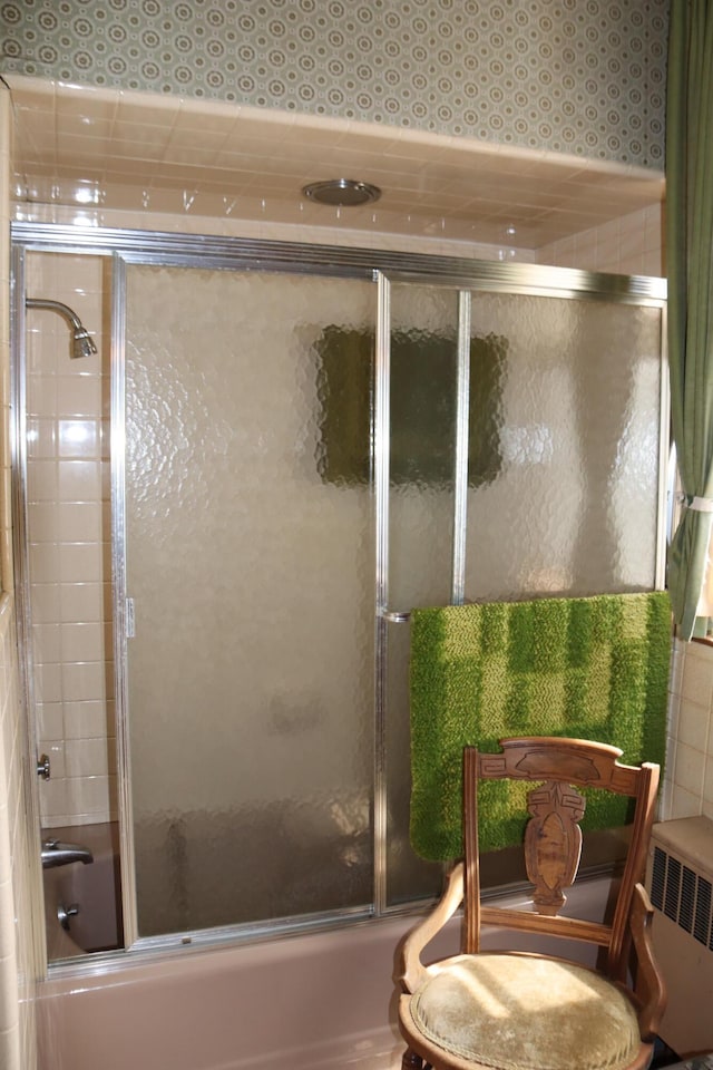 bathroom with enclosed tub / shower combo and radiator