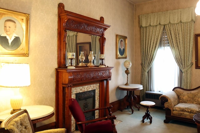 sitting room featuring a tile fireplace, radiator heating unit, and carpet floors