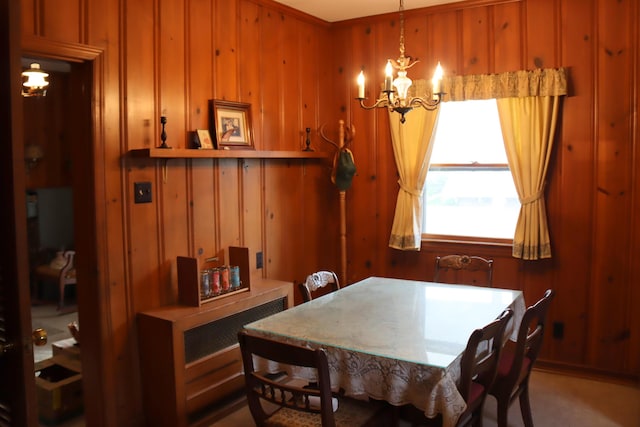 dining room featuring wooden walls and a notable chandelier