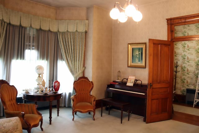 living area with light carpet and a chandelier